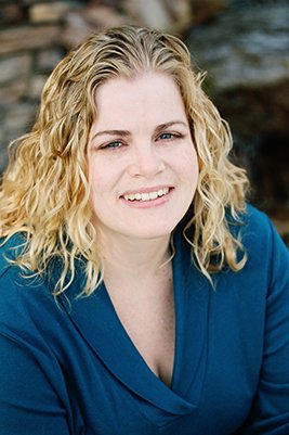 Crystal Jordan author photo - a white woman with wavy blonde hair and a teal v-neck shirt